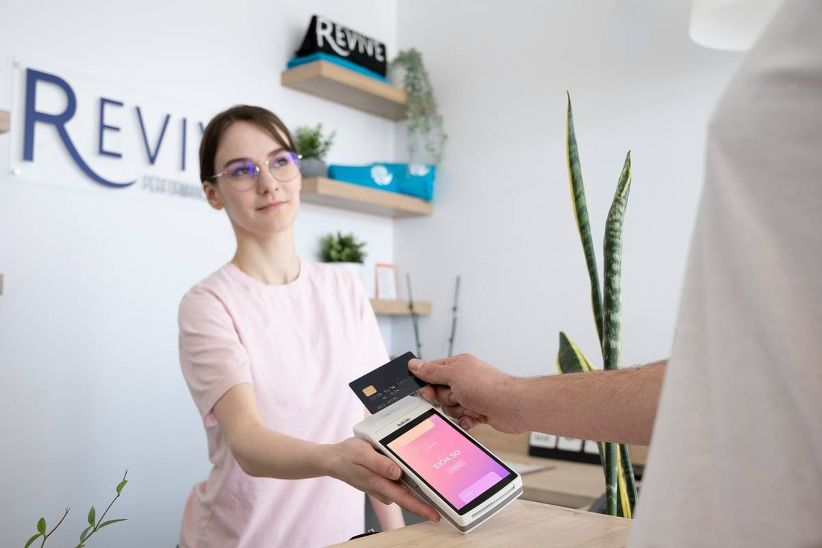 a woman is handing a card to a man